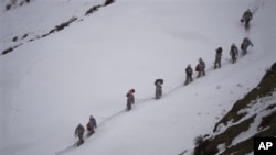 Tentara Pakistan membawa perbekalan menuju Kalpani Base, pos militer Pakistan di dekat perbatasan dengan India (Foto: dok). Pos militer Pakistan dan India di wilayah pegunungan Siachen Glacier ini terkubur salju longsor, Sabtu (7/4).