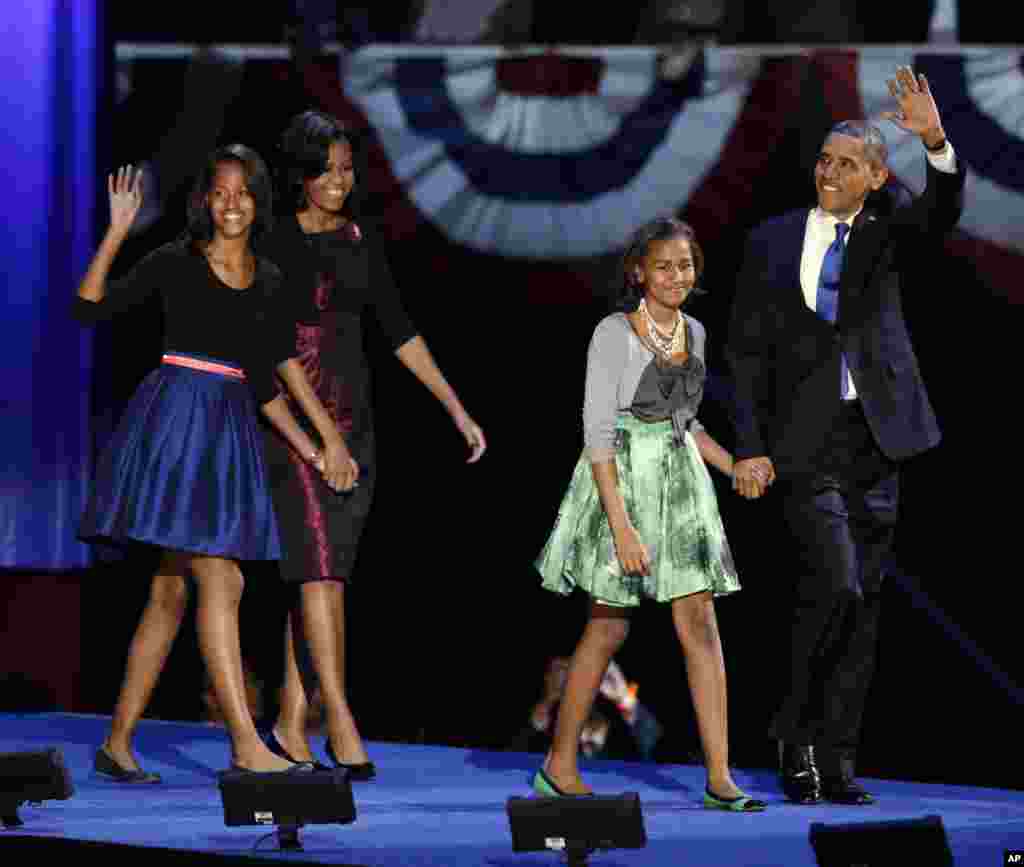 President Barack Obama waves as he walks on stage with first lady Michelle Obama and daughters Malia and Sasha at his election night party November 7, 2012, in Chicago, Illinois.