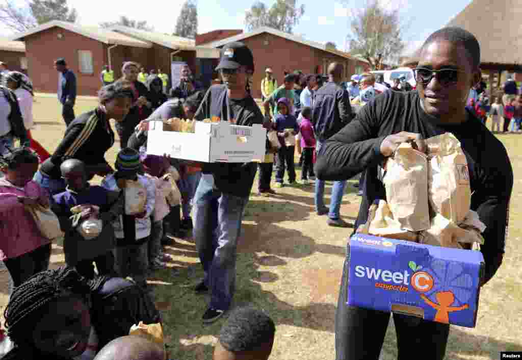 Nelson Mandela's grandson Zondwa Mandela gives out food parcels as they celebrate Mandela Day with 67 minutes of public service to honour the 67 years Mandela served humanity by first fighting against white-minority rule and then consolidating racial harmony when he was president, at the SOS children's home in Mamelodi township outside Pretoria July 18, 2013.