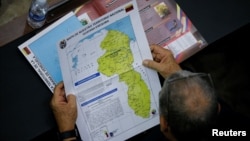 Un parlamentario venezolano revisa un mapa del territorio en disputa entre su país y Guyana desde el siglo XIX, conocido como El Esequibo, el 6 de diciembre de 2023, 