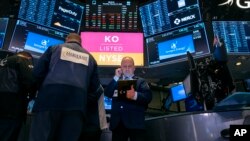 Corredores de Bolsa trabajan en medio de bajas de precio por el coronavirus y una guerra de precios del petróleo.