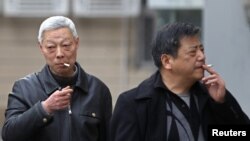 FILE - Smokers in a street in Shanghai, China.