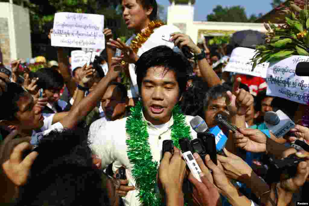 Political prisoners Yan Naing Tun (C) and Aung Min Naing (back C) talk to the media after being released from Insein prison in Rangoon, Burma, Dec. 31, 2013. 