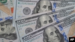FILE - $100 bills with the likeness of Benjamin Franklin are photographed in Dallas, Texas, Jan. 22, 2020.