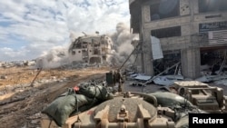 Asap mengepul dari sebuah gedung saat tentara Israel beroperasi di Jalur Gaza, dalam tangkapan layar yang diambil dari video selebaran yang dirilis pada 4 Desember 2023. (Foto: via Reuters)