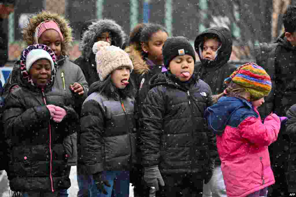 Children stand as snow begins to fall in New York City, Jan. 6, 2025.