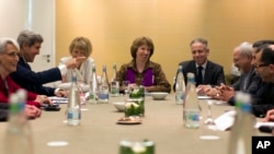 Menteri Luar Negeri John Kerry (kiri), bertemu dengan wakil Uni Eropa untuk urusan luar negeri Catherine Ashton (tengah) dan Menteri Luar Negeri Iran Mohammad Javad Zarif (ketiga dari kanan) di Jenewa (9/11). 
