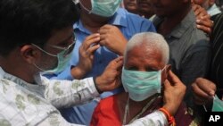 An Indian social activist distributes masks to pedestrians at the landmark Charminar in Hyderabad, India, March 5, 2020. 