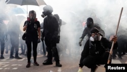 香港中文大學的學生們站在防暴警察發射的催淚彈煙霧中。（2019年11月12日）