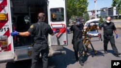 Los paramédicos del Departamento de Bomberos de Salem y los empleados de las ambulancias de Falck Northwest responden a una llamada de exposición al calor durante una ola de calor, el 26 de junio de 2021, en Salem, Oregón