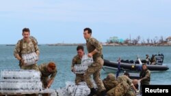 Members of the Humanitarian and Disaster Relief (HADR) team from the Royal Fleet Auxiliary's RFA Mounts Bay deliver supplies after Hurricane Dorian on the island of Great Abaco, Bahamas, Sept. 4, 2019.