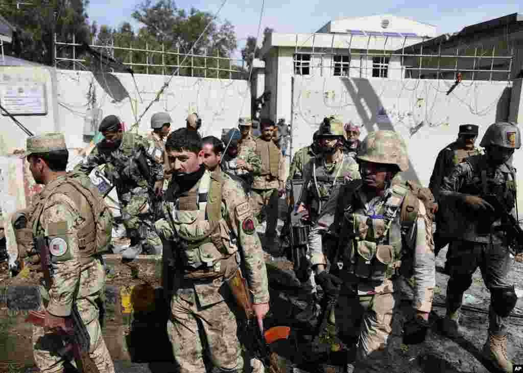 Afghan army and police search a police station after the Taliban staged a multi-pronged attack on a police station in Jalalabad, eastern Afghanistan, March 20, 2014.