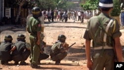 FILE PHOTO - Riot policemen protect themselves with shields as anti-government protesters throw rocks during a clash near the U.S. Embassy in Phnom Penh Wednesday, Sept. 9, 1998. Defiant opposition leaders vowed Wednesday to intensify mass protests against Cambodian leader Hun Sen, even as riot police used guns, clubs, cattle prods and water cannons to scatter rock-throwing demonstrators demanding his ouster. Police dispersed about 1,000 protesters after clashes near the U.S. Embassy and nearby residence of opposition leader Prince Norodom Ranariddh. Some regrouped later in smaller clusters around the city. (AP Photo/Ou Neakiry)