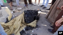 Egipcios se reunieron para observar un motor que se cree era del coche bomba usado en El Cairo, el jueves, 20 de agosto de 2015.
