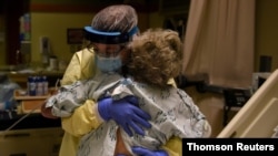FILE - Health care workers treat a patient at a hospital in Kansas. 