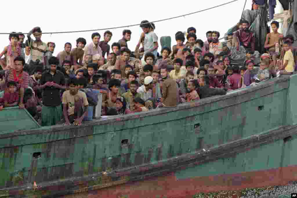 Migrants sit on their boat as they wait to be rescued by Acehnese fishermen on the sea off East Aceh, Indonesia, May 20, 2015.