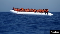 Migran di atas perahu karet menunggu diselamatkan oleh kapal Migrant Offshore Aid Station (MOAS) MV Phoenix, 32 kilometre di perairan lepas pantai Libya, 3 AGustus 2015 (Foto: dok).