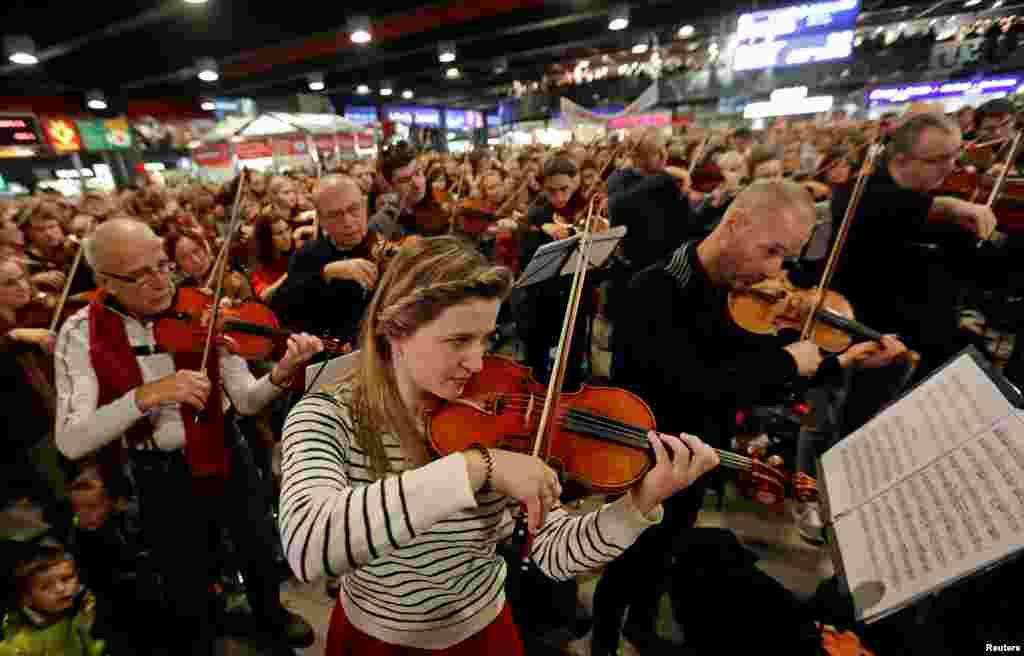 Un grupo de personas cantan y tocan instrumentos durante la presentación de la "Misa de Navidad checa" del compositor checo Jakub Jan Ryba en la estación principal de trenes de Praga, República Checa.