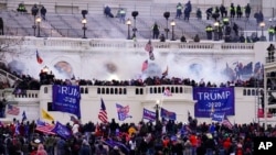 Para pendukung Donald Trump menyerbu Gedung Capitol AS dalam sebuah serangan untuk menggagalkan pengesahan kemenangan Joe Biden dalam pemilu presiden 2020, pada 6 Januari 2021. (Foto: AP/John Minchillo)