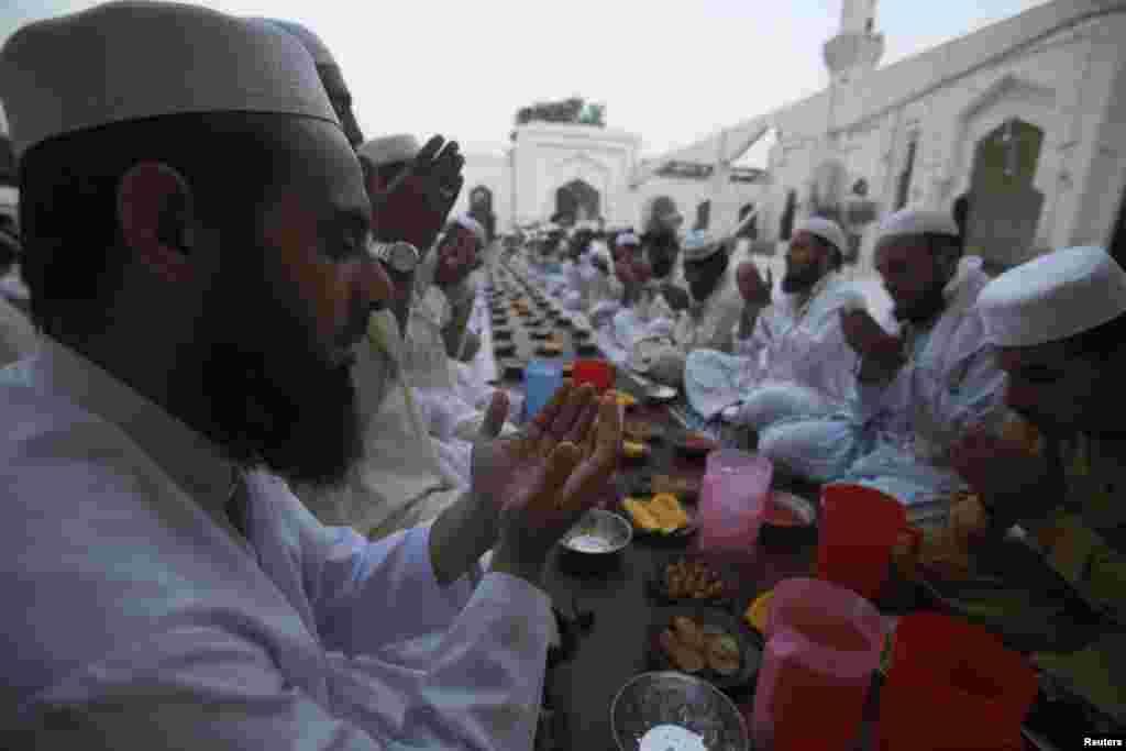 Men pray before breaking their fast on the first day of Ramadan, the holiest month in the Islamic calendar, at a mosque in Peshawar, Pakistan, June 29, 2014.