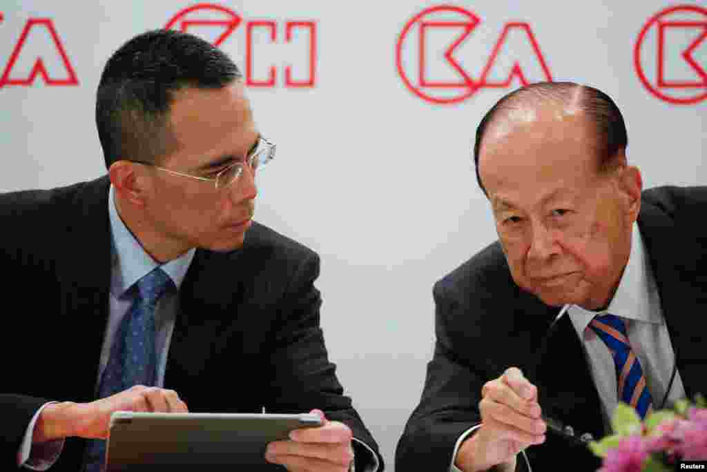 香港大亨李嘉诚2018年3月16日在香港举行的新闻发布会上听他的儿子、长江和记实业集团联席董事总经理兼副主席李泽钜说话。当天李嘉诚宣布退休,其商业王国交由他53岁的长子李泽钜接手。李嘉诚将于今年7月年满90岁。李嘉诚说,如果他是人大代表,就会投票支持修改宪法。有网民说他用手投支持票,用脚投反对票。意思是他曾把大量资产撤出中国。一些网民为此称赞李嘉诚的远见。