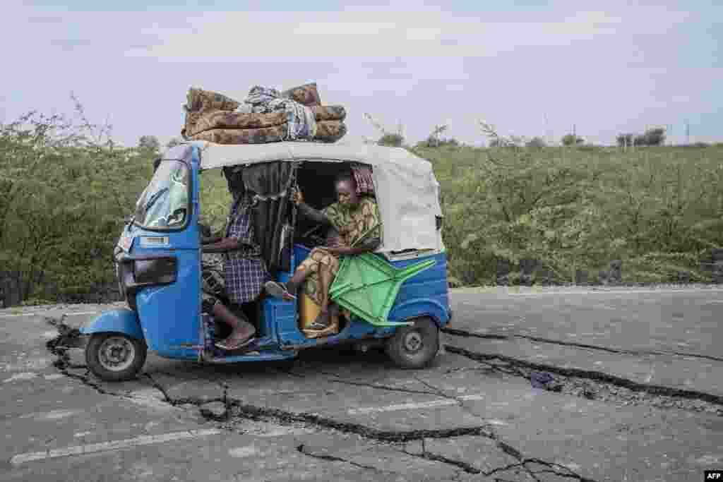 Residents ride a tuk-tuk taxi along a road damaged by multiple earthquakes near the town of Kabanna. Evacuations and displacement are underway in Ethiopia after a series of earthquakes rocked the remote north of the Horn of Africa nation. The earthquakes have damaged houses and threatened to trigger a volcanic eruption of the previously dormant Mount Dofan, near Segento in the northeast Afar region.
