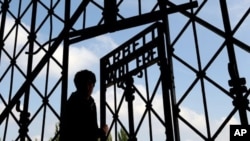 FILE - A visitor enters the Dachau Nazi concentration camp in Germany.