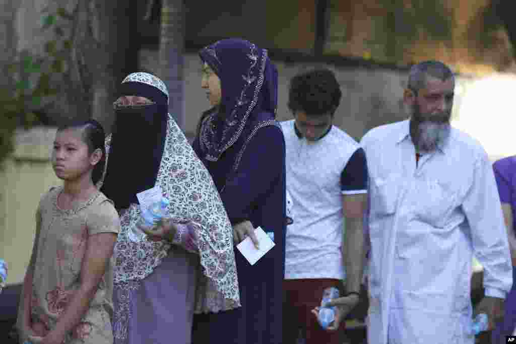 Umat Muslim mengantri untuk memberikan suara mereka di luar TPS di Mandalay, 8 November 2015.