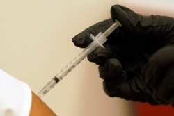 A woman is injected with her second dose of the Pfizer COVID-19 vaccine at a Dallas County Health and Human Services vaccination site in Dallas, Aug. 26, 2021.