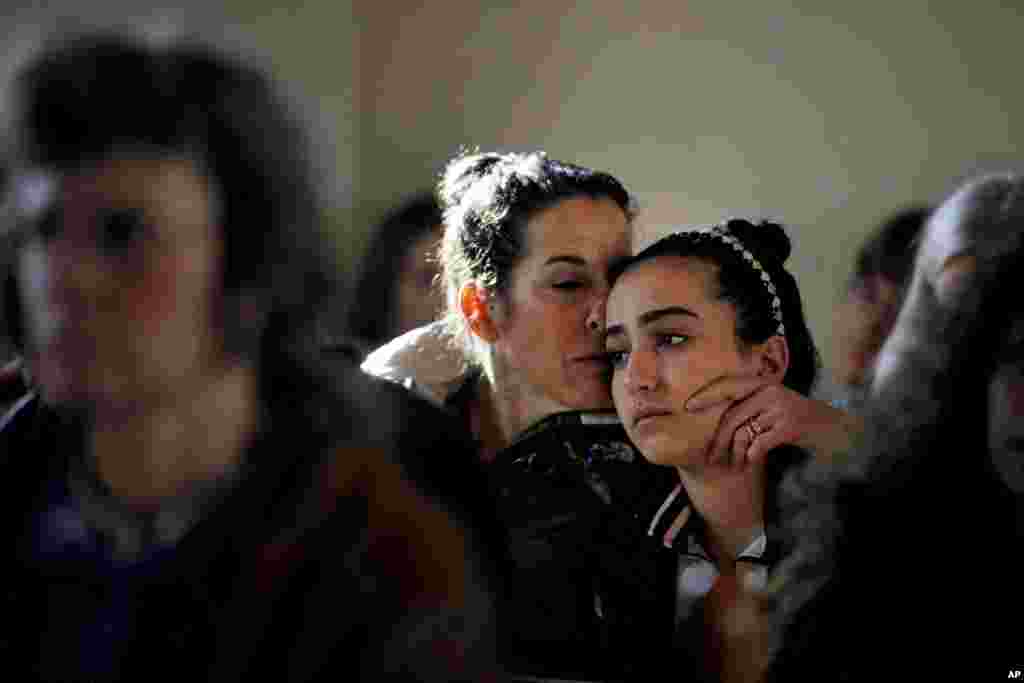 Elizabeth Bogdanoff (kiri) mencium putrinya Julia (13 tahun) dalam kebaktian di gereja Episcopal St John di Newtown, Connecticut, 15 Desember 2012.