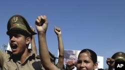 Cuban military cadets chant slogans as they march in the parade commemorating the 50th anniversary of the Bay of Pigs failed invasion along the Plaza de la Revolucion or Revolution Square in Havana, Cuba, Saturday April 16, 2011.