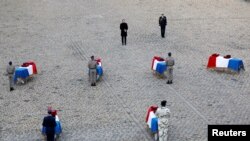 FILE - French President Emmanuel Macron pays his respect in front of the flag-draped coffins of the thirteen French soldiers killed in Mali, during a ceremony at the Hotel National des Invalides in Paris, France, Dec. 2, 2019.