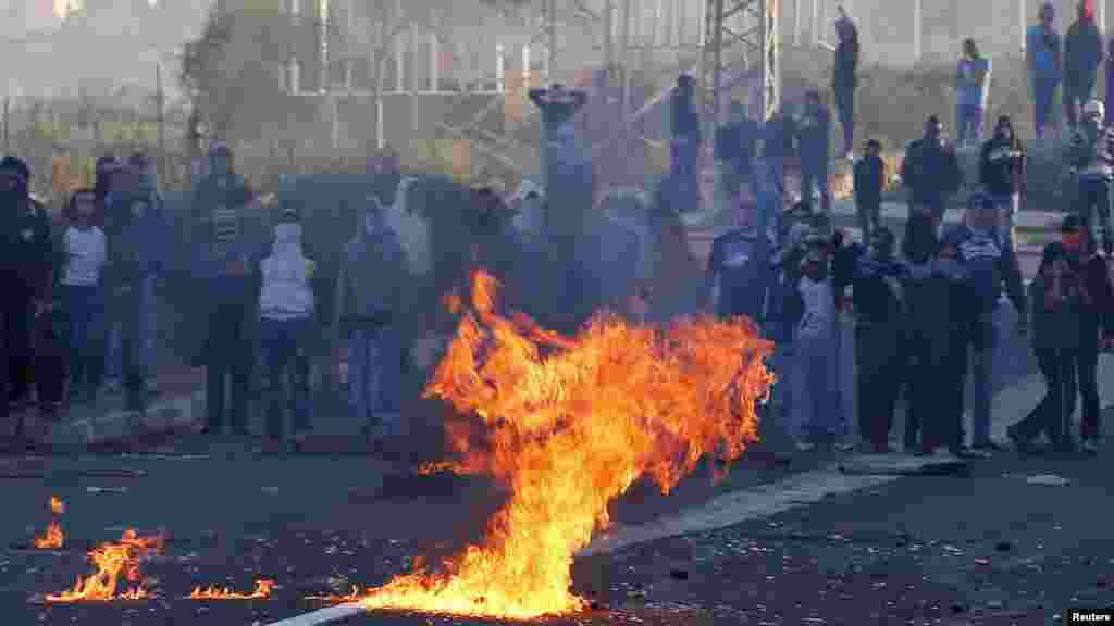 Israeli Arab youths clash with Israeli police at the entrance to the town of Kfar Kanna, Israel, Nov. 8, 2014.