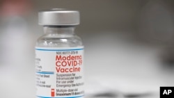 FILE - A vial of the Moderna COVID-19 vaccine is displayed on a counter at a pharmacy in Portland, Ore., Dec. 27, 2021.