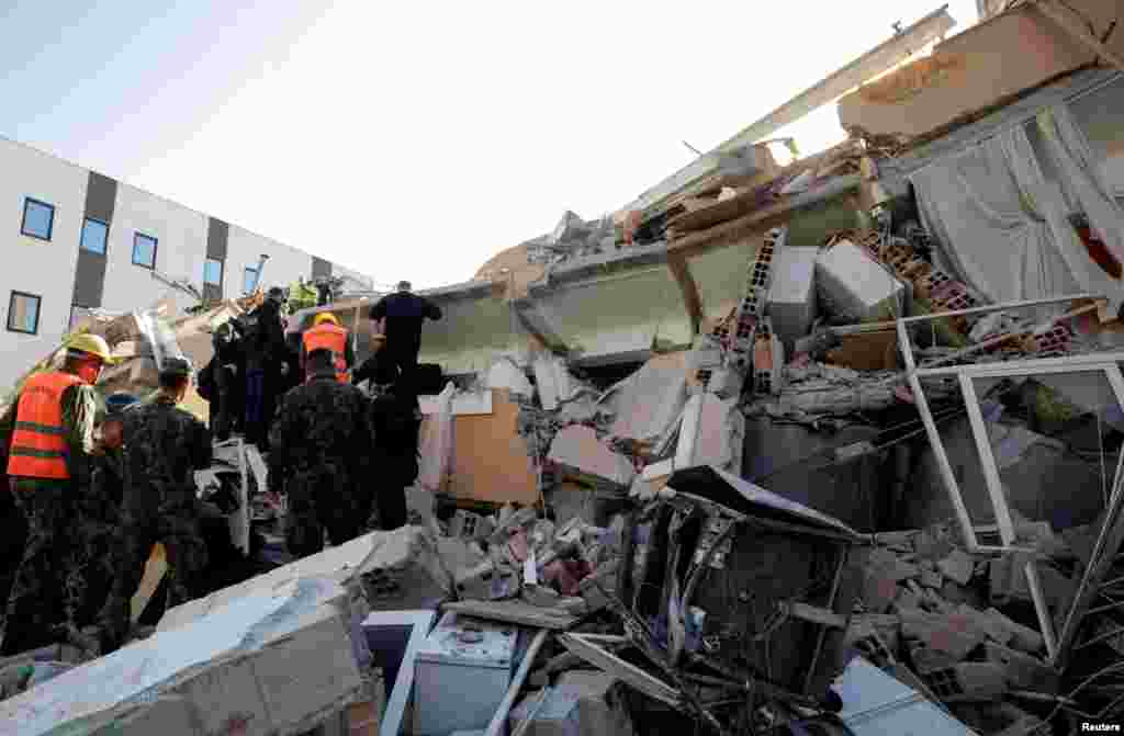 Military and emergency personnel work near a damaged building in Durres, after an earthquake shook Albania, Nov. 26, 2019.