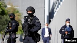Polisi mengamankan pintu masuk gedung pengadilan saat pembukaan persidangan serangan Paris Januari 2015 majalah satir mingguan Charlie Hebdo, seorang polisi wanita di Montrouge dan supermarket halal Hyper Cacher, di Paris, Perancis, 2 September 2020.