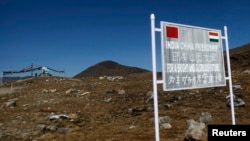 FILE - A signboard is seen from the Indian side of the Indo-China border at Bumla, in the northeastern Indian state of Arunachal Pradesh.