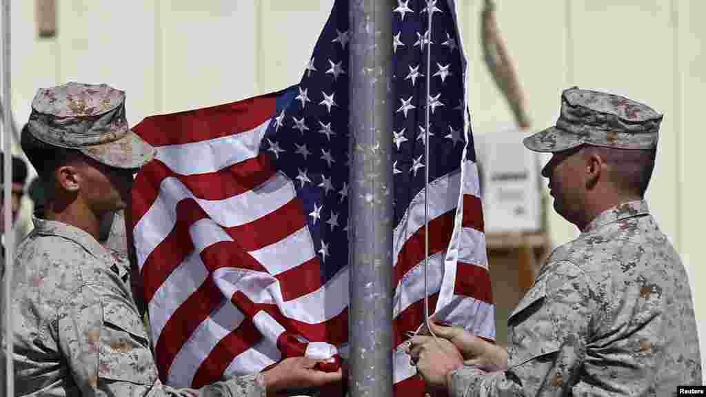 U.S. Marines lower their flag during a handover ceremony, as the last U.S. Marines unit and British combat troops end their Afghan operations, in Helmand province, Oct. 26, 2014.