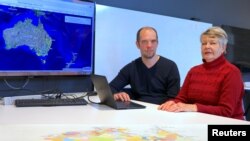 University of Newcastle research academic, Professor Lyndall Ryan, right, and researcher Bill Pascoe sit in front of a screen, July 18, 2018, displaying a map detailing the number of Aboriginal and Torres Strait Islander massacres that occurred on Australia’s colonial frontier.