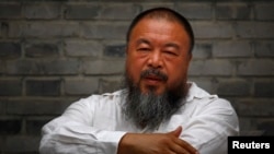 Chinese dissident artist Ai Weiwei sits on a chair in the courtyard of his studio, in Beijing, June 20, 2012.