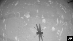 FILE - In this photo made available by NASA, the Mars Ingenuity helicopter photographs its shadow with its black-and-white navigation camera during its second flight on Apr. 22, 2021. (NASA/JPL-Caltech via AP)