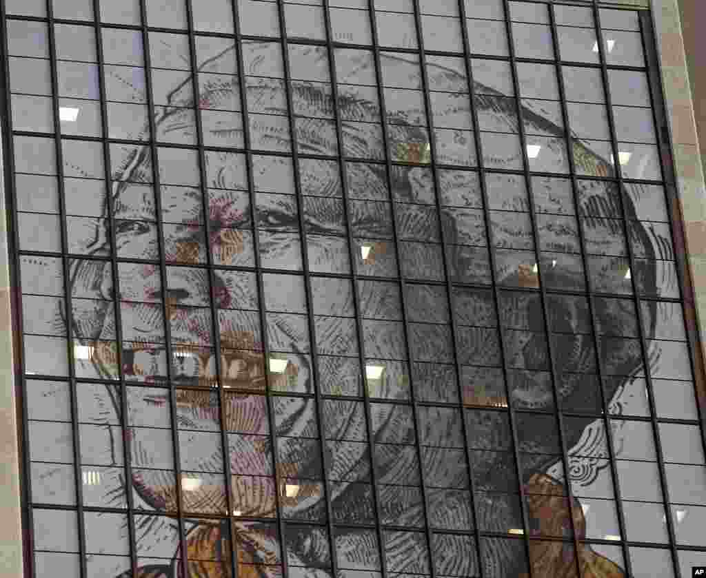 A portrait of Mandela is displayed on the windows of a building on his 95th birthday, Cape Town, South Africa, July 18, 2013.