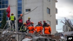Tim penyelamat dari Perancis dan Swiss berada di sebuah bangunan yang runtuh setelah gempa berkekuatan 6,4 SR di Durres, Albania barat, 29 November 2019. (Foto: AP)