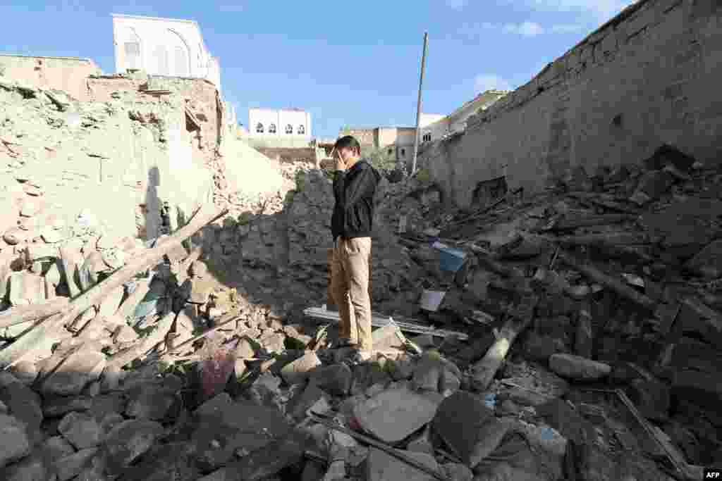 Seorang laki-laki Suriah berdiri di atas puing-puing setelah terjadi serangan roket malam sebelumnya di daerah Bab al-Hadiid yang diperebutkan di kota utara, Aleppo. Pernah menjadi pusat ekonomi Suriah, Aleppo kini rusak karena pertempuran yang dimulai pada pertengahan 2012. Kota itu sekarang terbagi antara pasukan pemerintah yang menguasai bagian barat dan pemberontak yang menguasai wilayah timur kota. 
