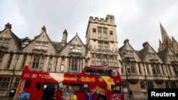 FILE - A sightseeing bus passes Oxford University building, amid the spread of the coronavirus disease (COVID-19), in Oxford, Britain, Oct. 6, 2020.