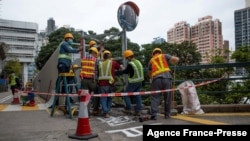 Pekerja konstruksi di Universitas Hong Kong menggunakan terpal logam untuk menutupi salah satu penghormatan publik terakhir kota itu untuk penumpasan Lapangan Tiananmen 1989, 29 Januari 2022. (Foto: AFP)