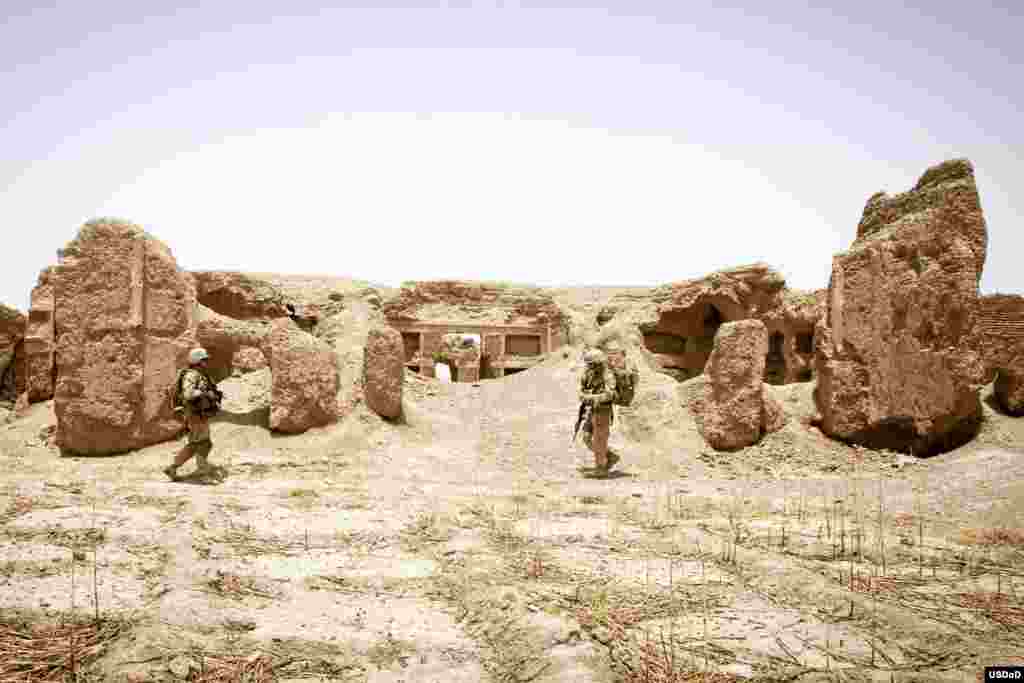 U.S. Navy Hospital Corpsman 1st Class William Neason, left, and U.S. Marine Corps 1st Lt. Stephen T. Desmond, both with the Georgian Liaison Team 9, patrol through the ruins of a 200 year-old castle during Operation Northern Lion in Mohammadabad, Helmand province, Afghanistan. Northern Lion was a Georgian-led Operation conducted to deter insurgents, establish a security presence and gather human intelligence in the area. (U.S. Marine Corps photo by Staff Sgt. Ezekiel R. Kitandwe)