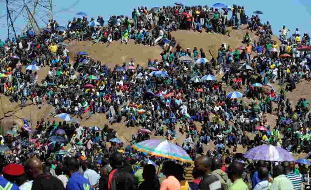 Mine workers sit on a hill where a year ago, police opened fire on fellow workers killing 34 and injuring 78, near the Marikana mine, South Africa, August 16, 2013.