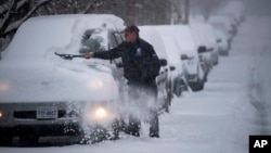Russ Sprinkel removes snow from his vehicle on Washington Avenue in Roanoke, Va. as snow continues to fall throughout Southwest Virginia, Sunday, Dec. 9, 2018. 