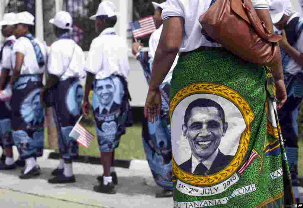 Young girls and women wear the khanga, a traditional wrap, with the image of U.S. President Barack Obama as they line up to greet him at the State House, in Dar es Salaam, Tanzania, July 1, 2013.